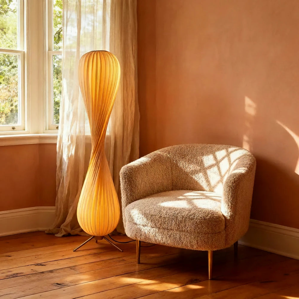 Modern floor lamp and chair in a sunlit room with warm lighting