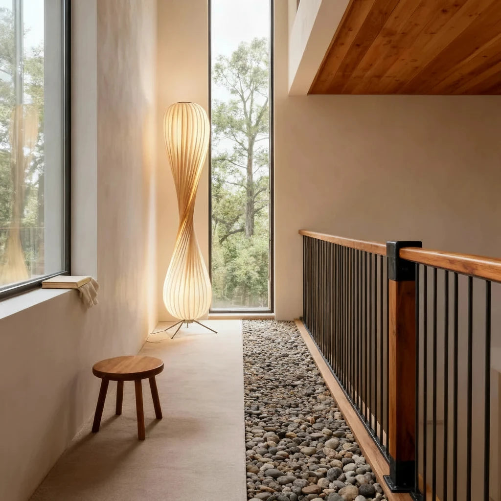 Modern floor lamp in a room with large windows and a wooden stool.